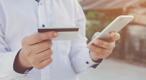 This photo of someone using a gift card to make a purchase on a smartphone demonstrates the gift card fundraising idea.